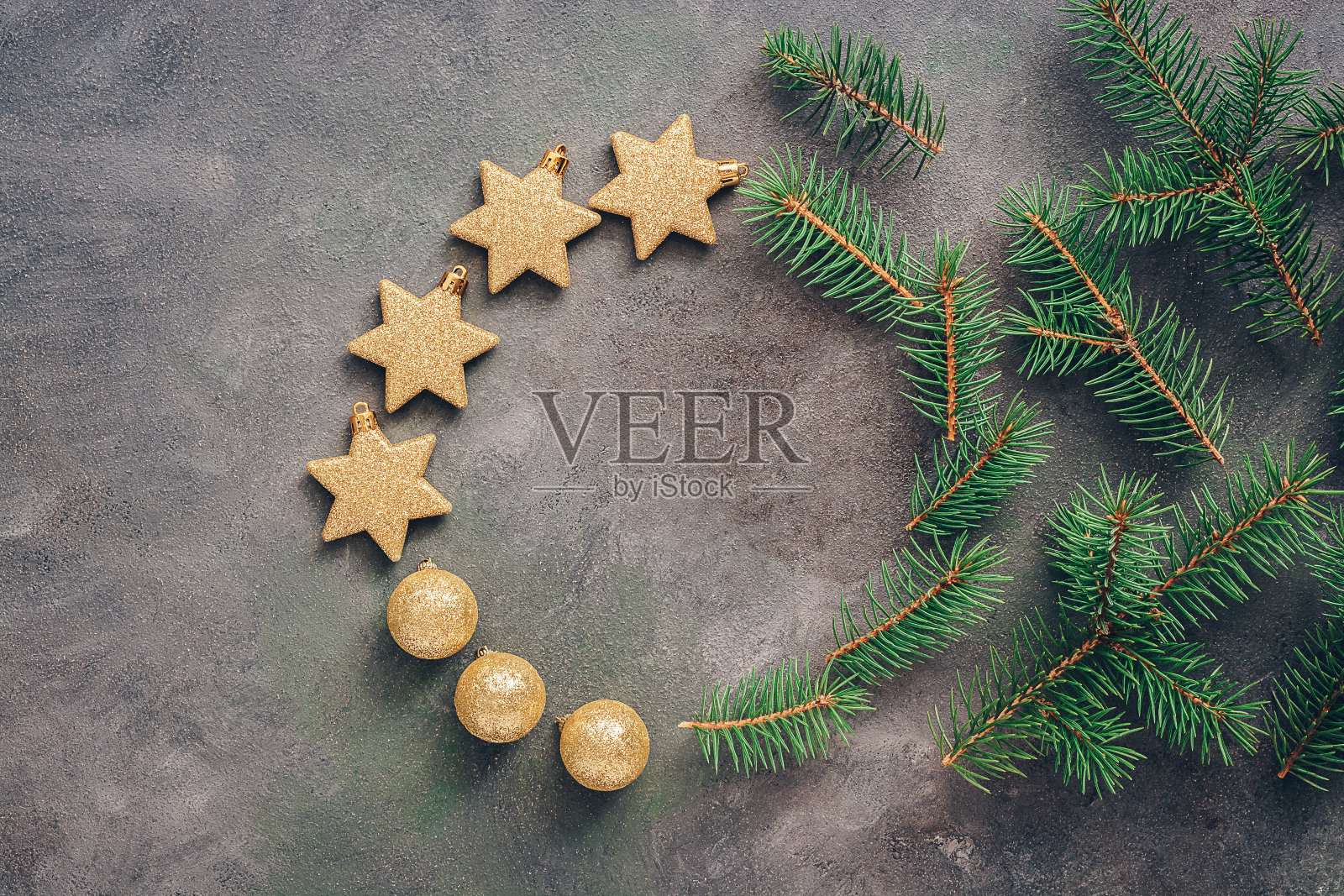 美丽的圆形圣诞框架从冷杉树枝，金色的球和星星在黑暗的乡村背景。俯视图，平放，复制空间。照片摄影图片