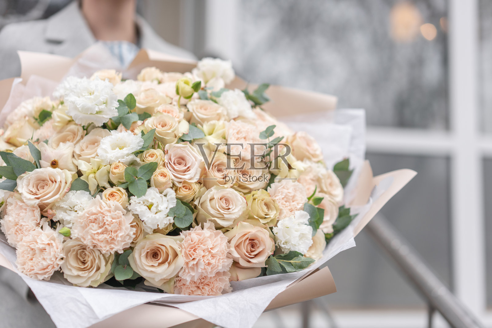 女人手里拿着一大束美丽的混合鲜花。粉红色和白色。花店花匠的工作。精致柔和的颜色。新鲜切花。照片摄影图片