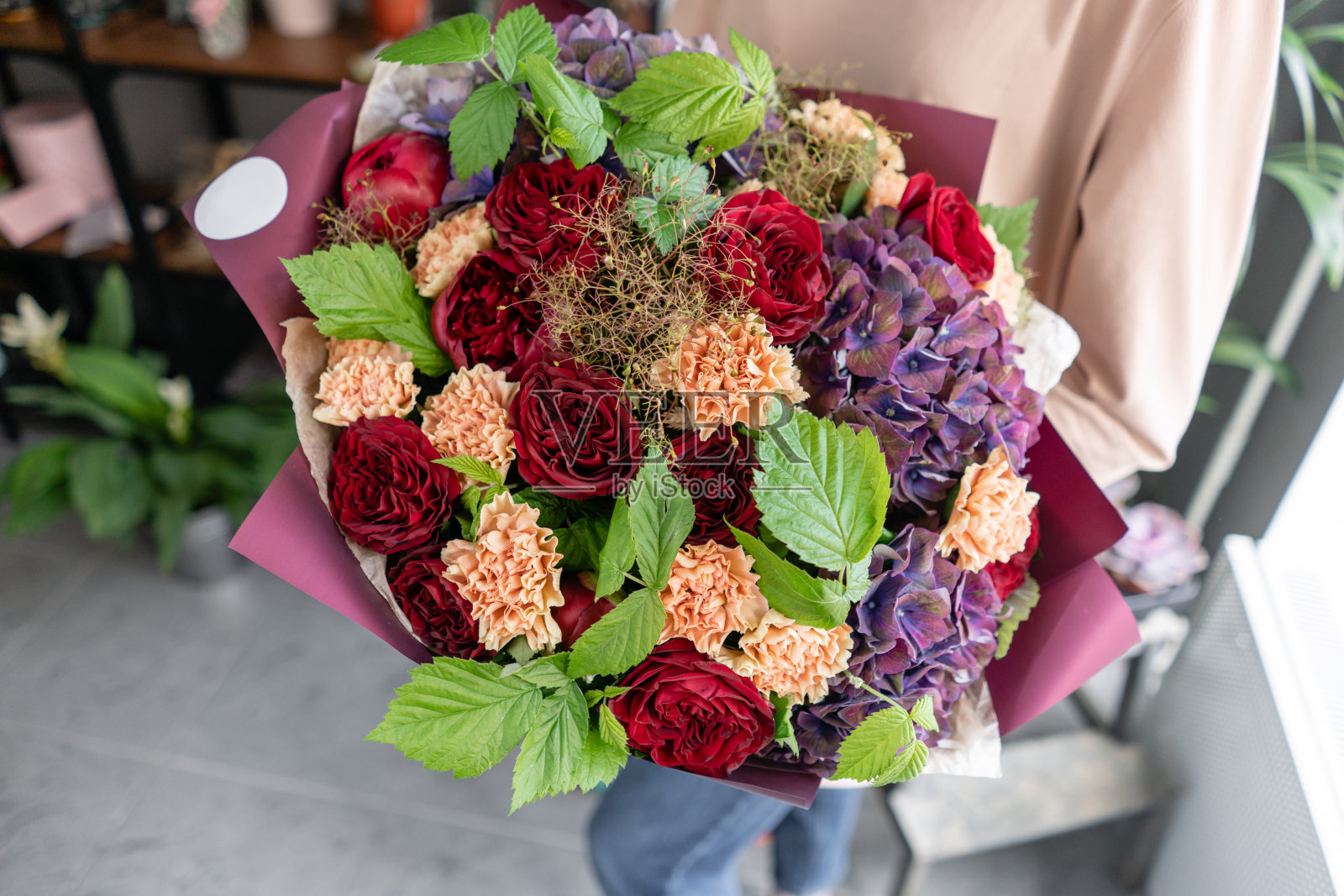 女人手里拿着一大束美丽的混合鲜花。花店概念。漂亮的新鲜花束。鲜花交付照片摄影图片