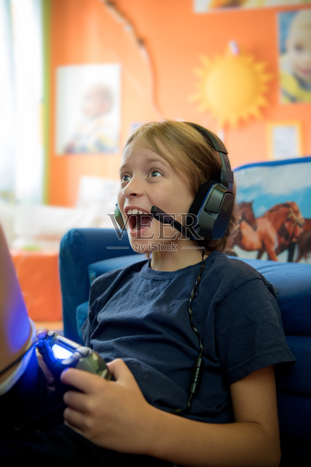 兴奋和快乐的小男孩9岁玩电子游戏照片摄影图片