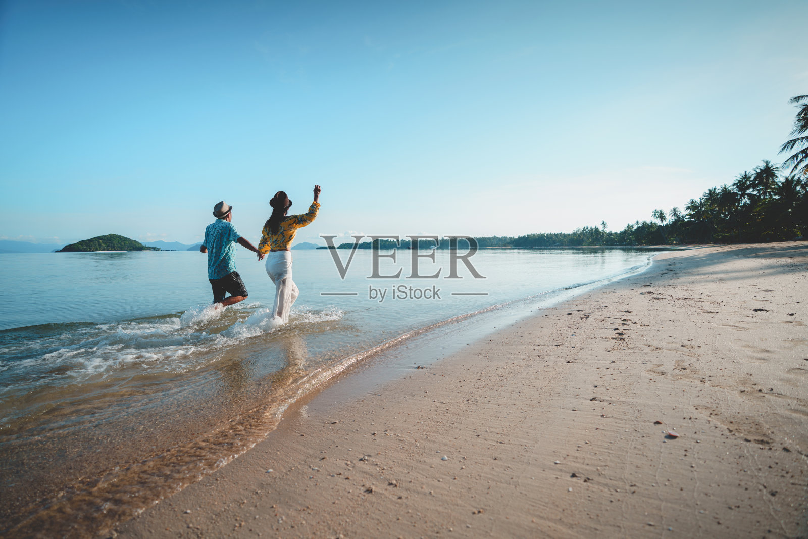 一对快乐的中年夫妇在沙滩上跑步照片摄影图片