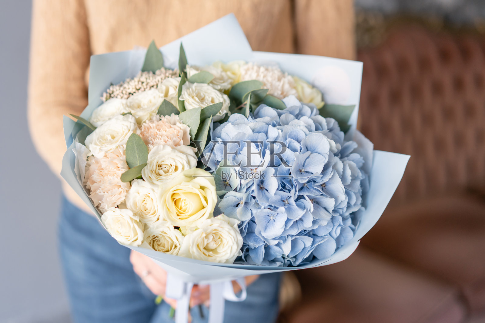 白色和蓝色。女人手里捧着一束美丽的混合鲜花。花店花匠的工作。新鲜切花。照片摄影图片