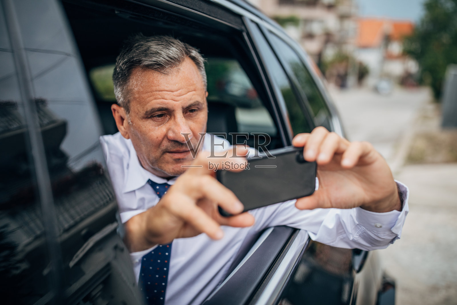 老人开车，用手机拍照照片摄影图片