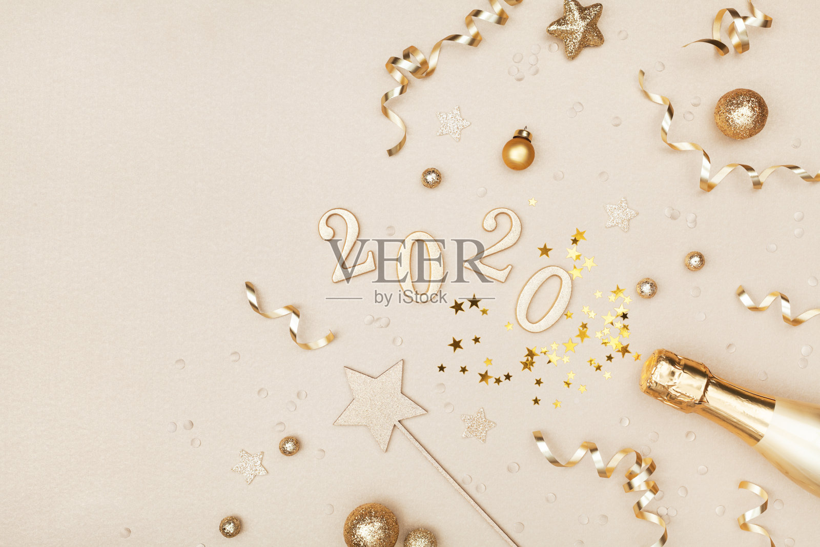 用金色的香槟酒瓶、节日装饰、五彩缤纷的星星和2020数字来庆祝圣诞和新年。照片摄影图片