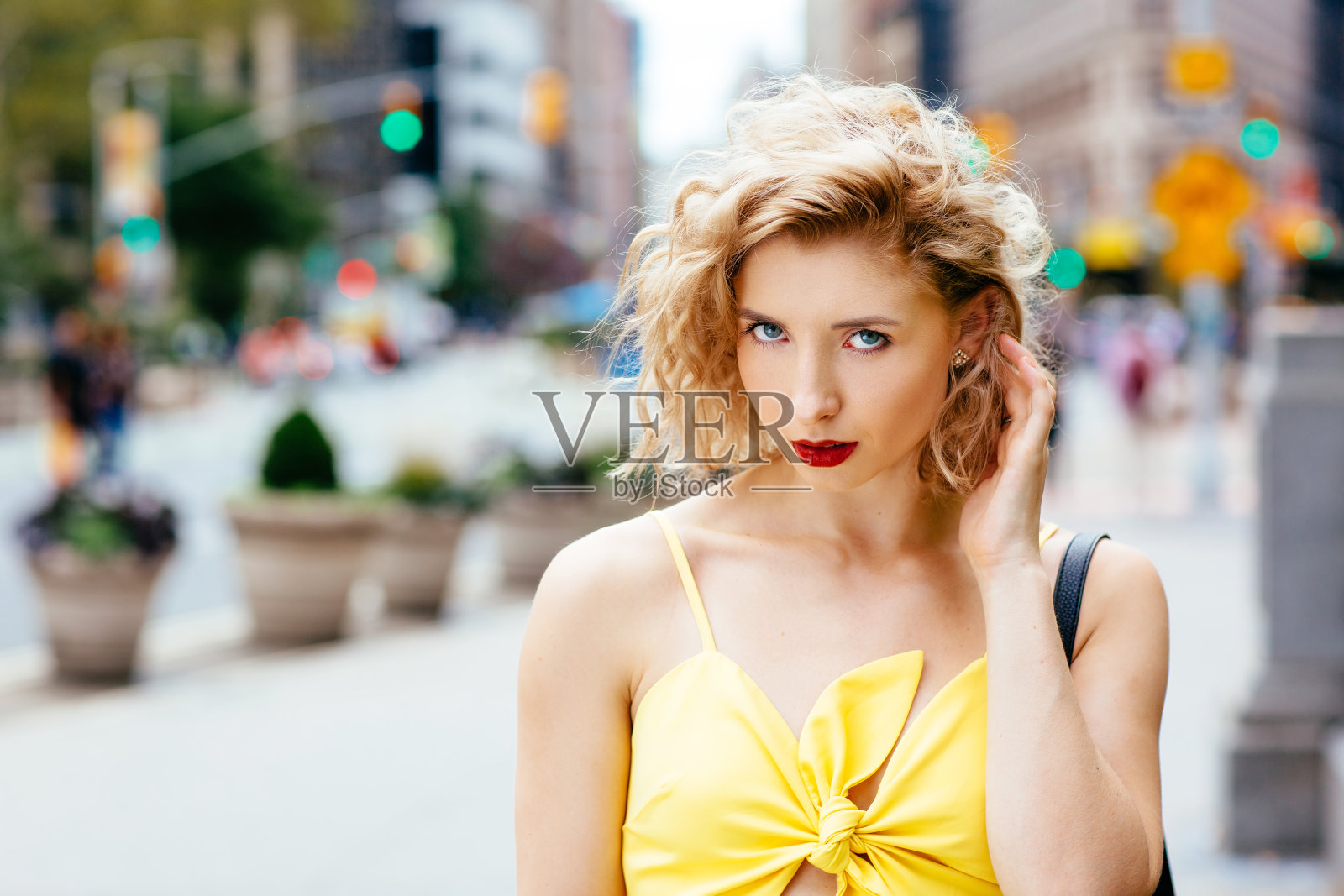 一个穿着黄色衣服走在城市里的性感年轻女子的肖像照片摄影图片