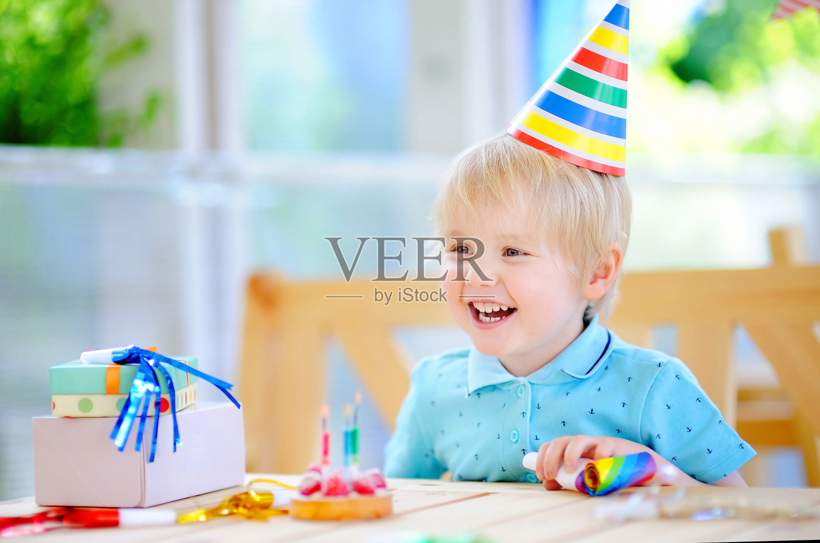 可爱的小男孩玩得很开心，用五颜六色的装饰和蛋糕庆祝生日派对照片摄影图片