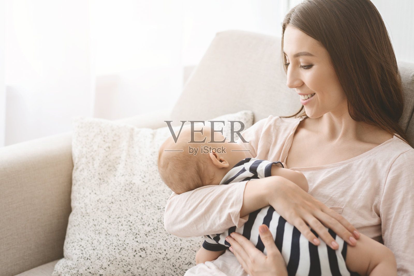 年轻母亲的肖像和可爱的婴儿手上的婴儿照片摄影图片