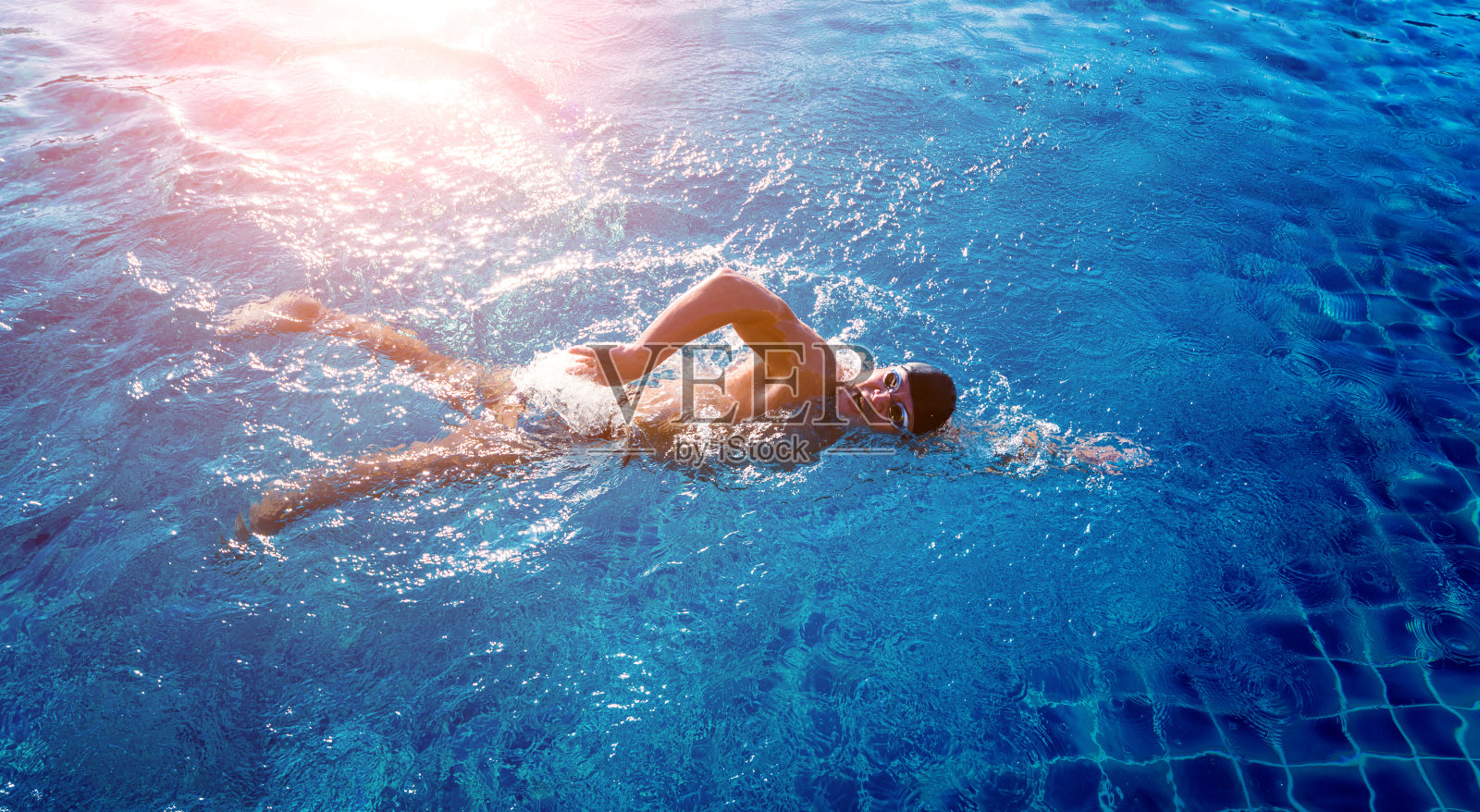 一个年轻的运动员在游泳池里游泳照片摄影图片
