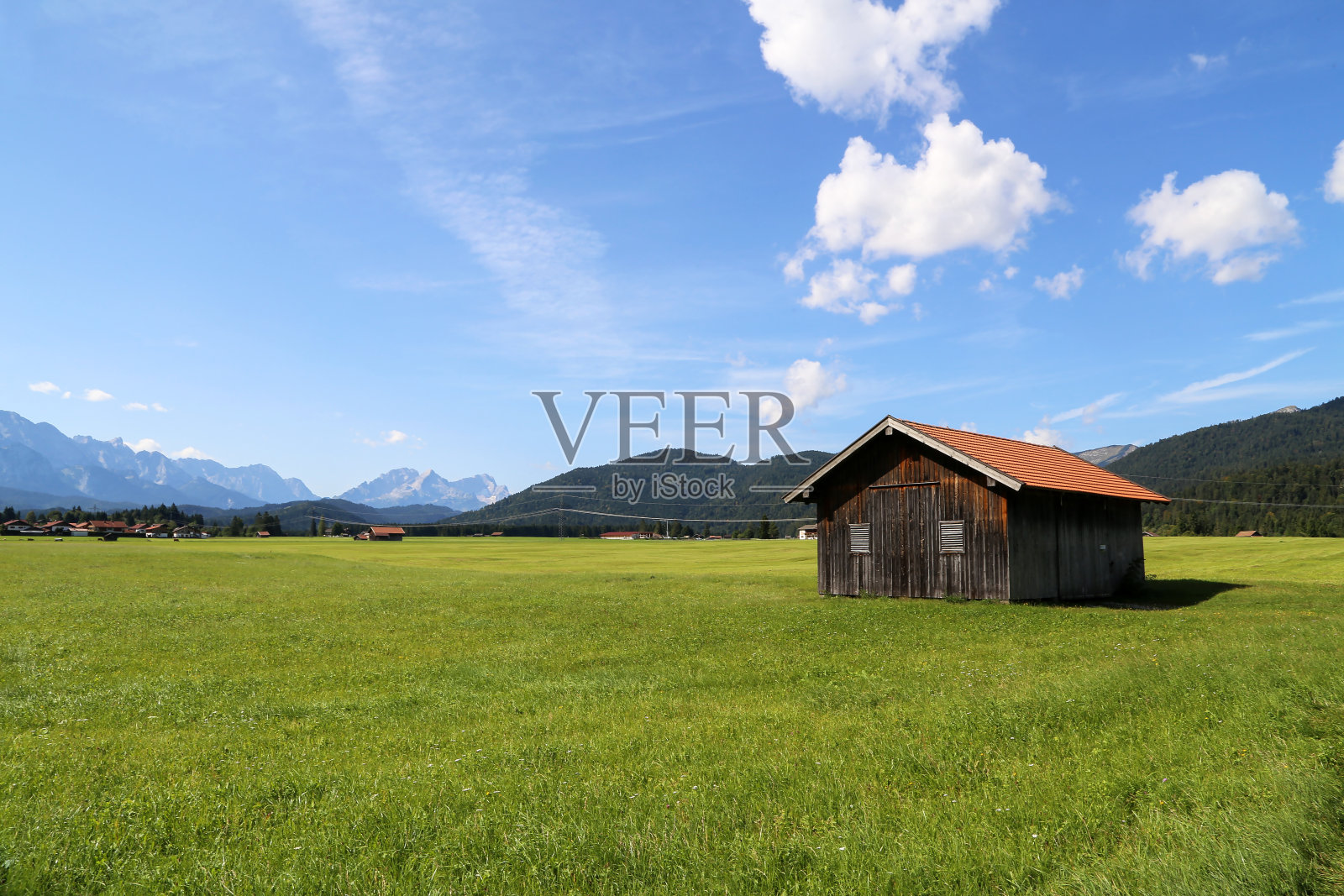 在阿尔卑斯山的绿色草地上的山上小屋照片摄影图片
