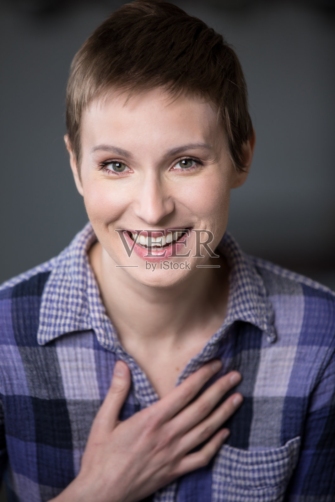 一个留着短发的中年女人坐在厨房里笑照片摄影图片