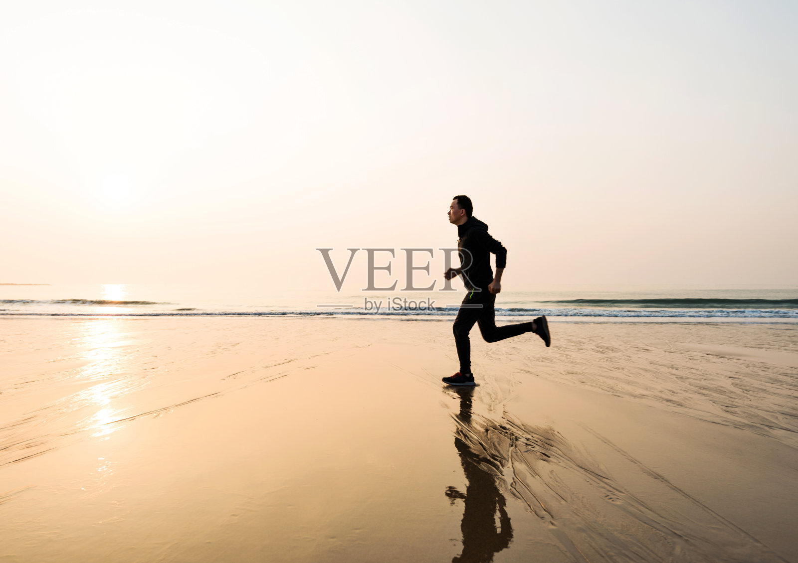 日落时分沙滩上奔跑的人照片摄影图片