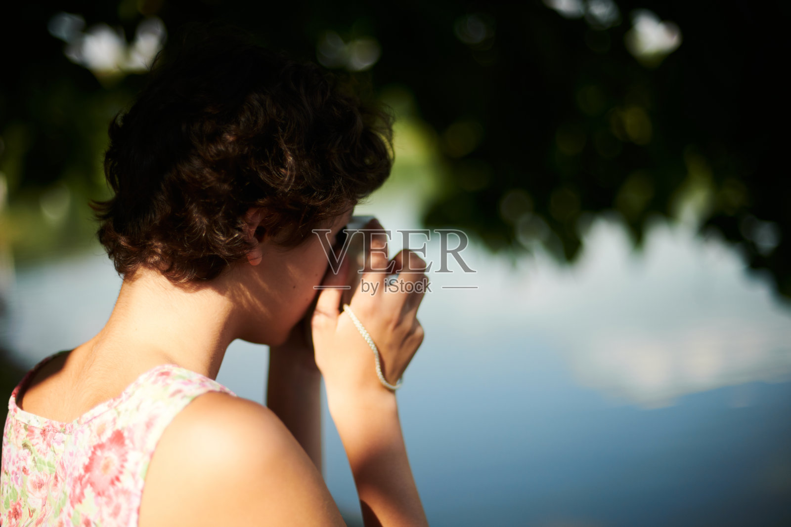 活泼的女孩在阳光明媚的森林里用瞬间相机拍照照片摄影图片