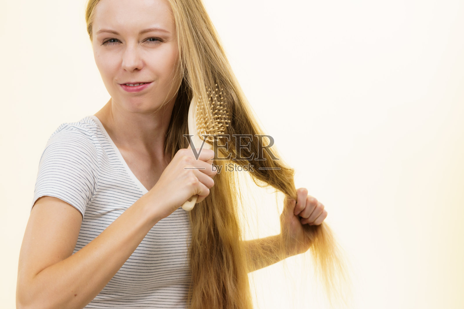 金发女孩正在梳理她的长发照片摄影图片