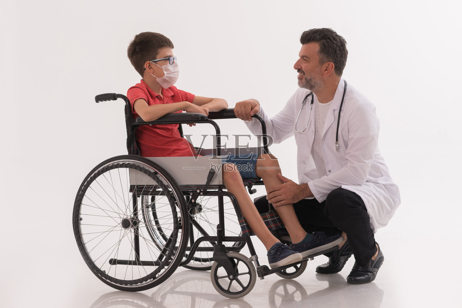 坐在轮椅上的残疾男孩与医生交谈照片摄影图片