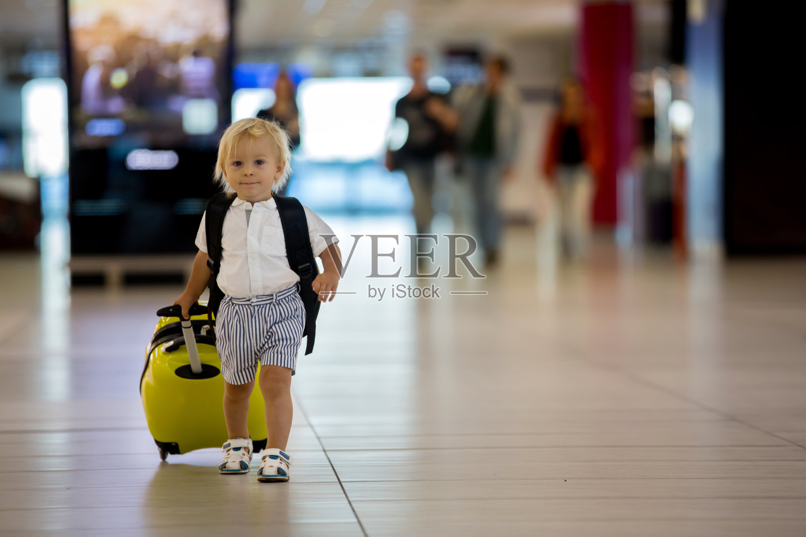 可爱的孩子，男孩，在机场走着，拿着行李箱和背包照片摄影图片