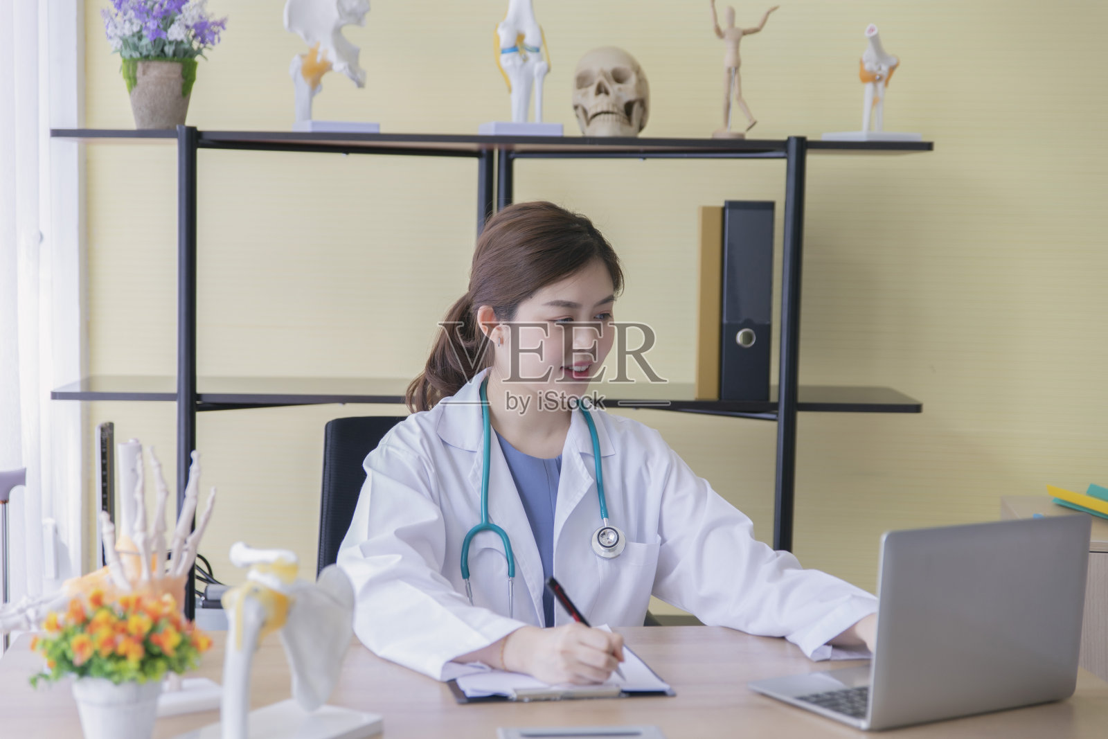 亚洲女医生在办公室用笔记本电脑工作。照片摄影图片