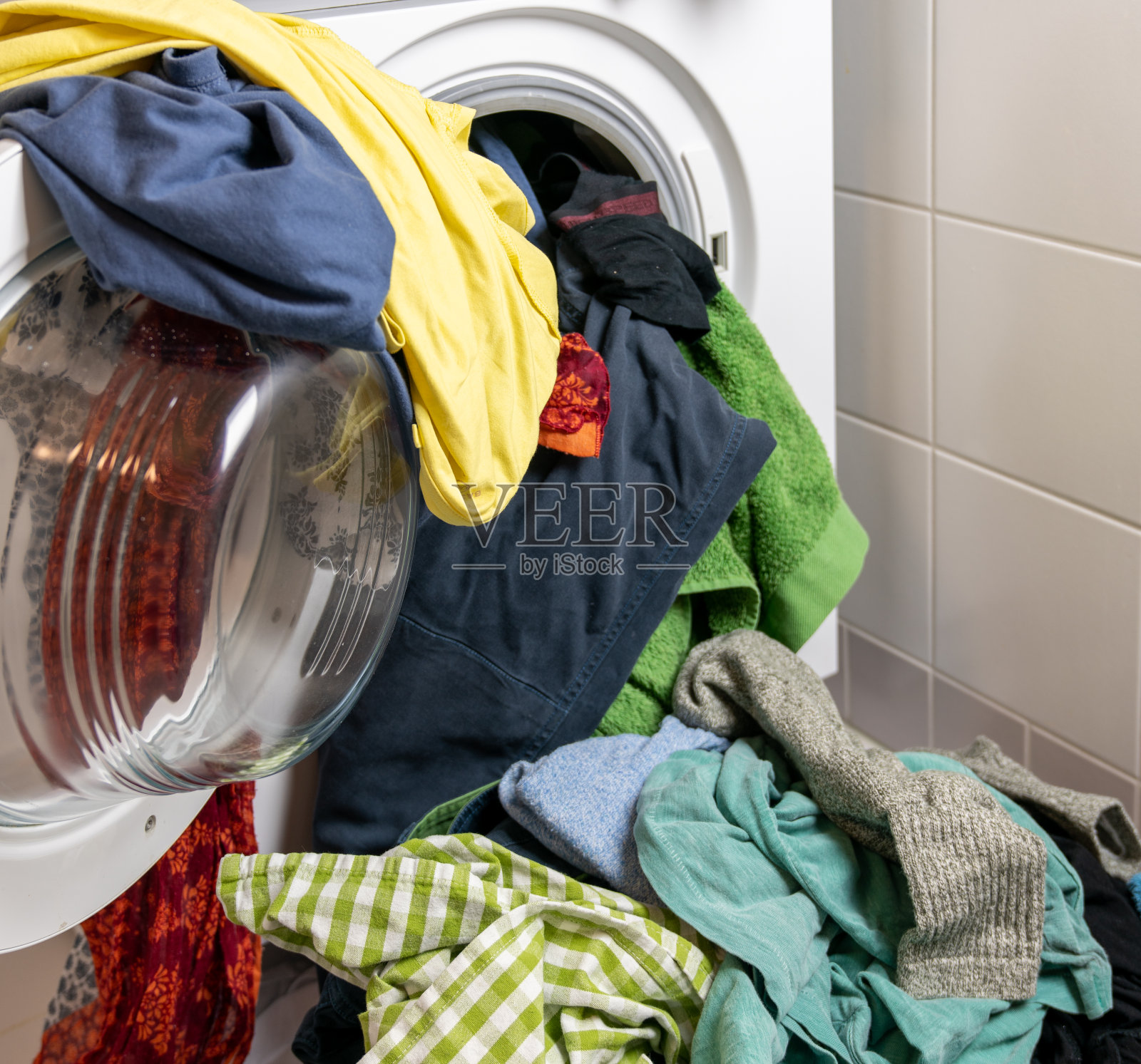 一大堆五颜六色的脏衣服洗衣机里塞满了衣服照片摄影图片