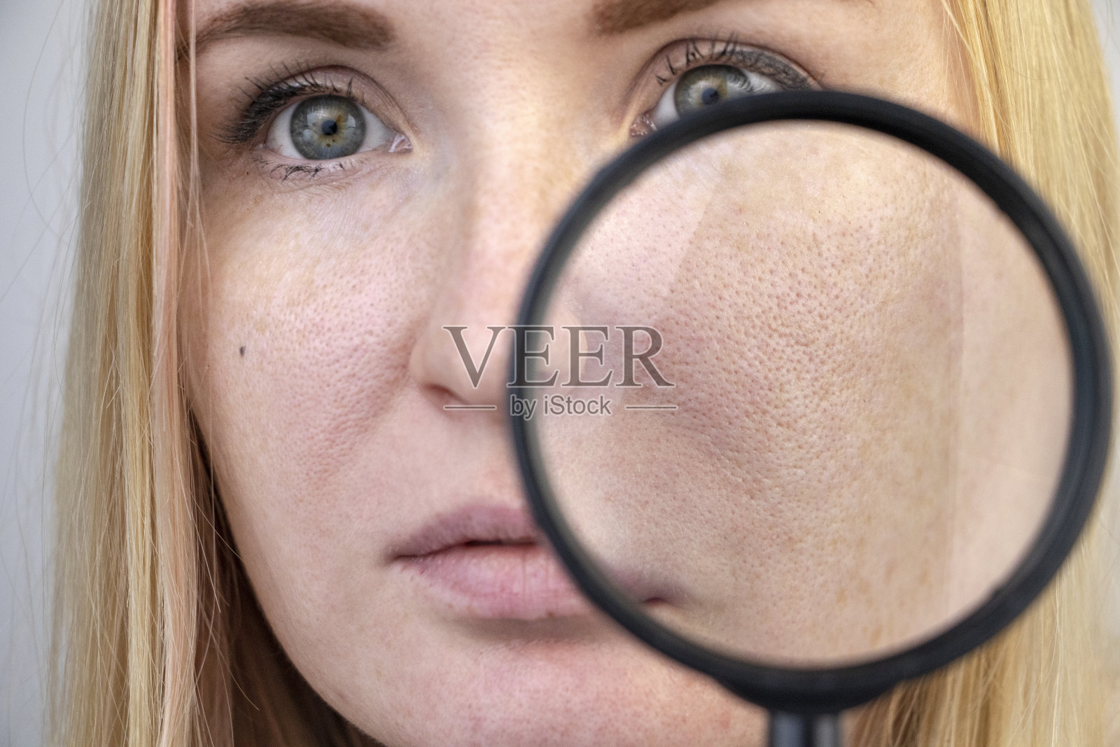 毛孔增大，黑斑，痤疮，酒糟鼻近距离在脸颊。一位妇女正在接受医生的检查。皮肤科医生通过放大镜检查皮肤照片摄影图片