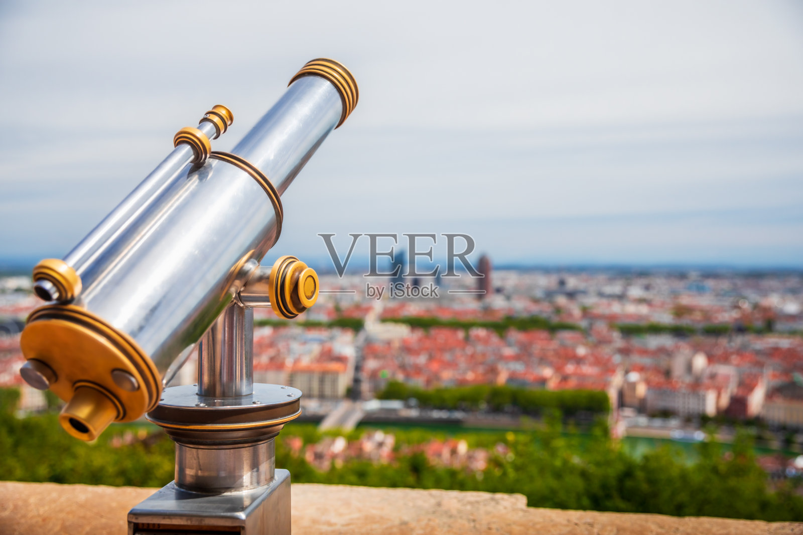 单筒望远镜为游客从富维埃山俯瞰法国里昂市，美丽的城市景观在背景模糊照片摄影图片