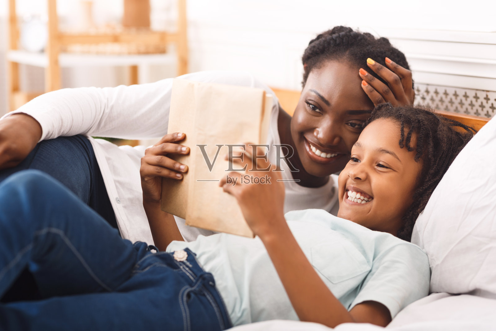 快乐的黑人家庭在卧室看书照片摄影图片