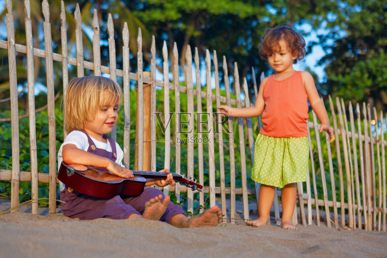 孩子们在日落热带海滩上玩耍。照片摄影图片