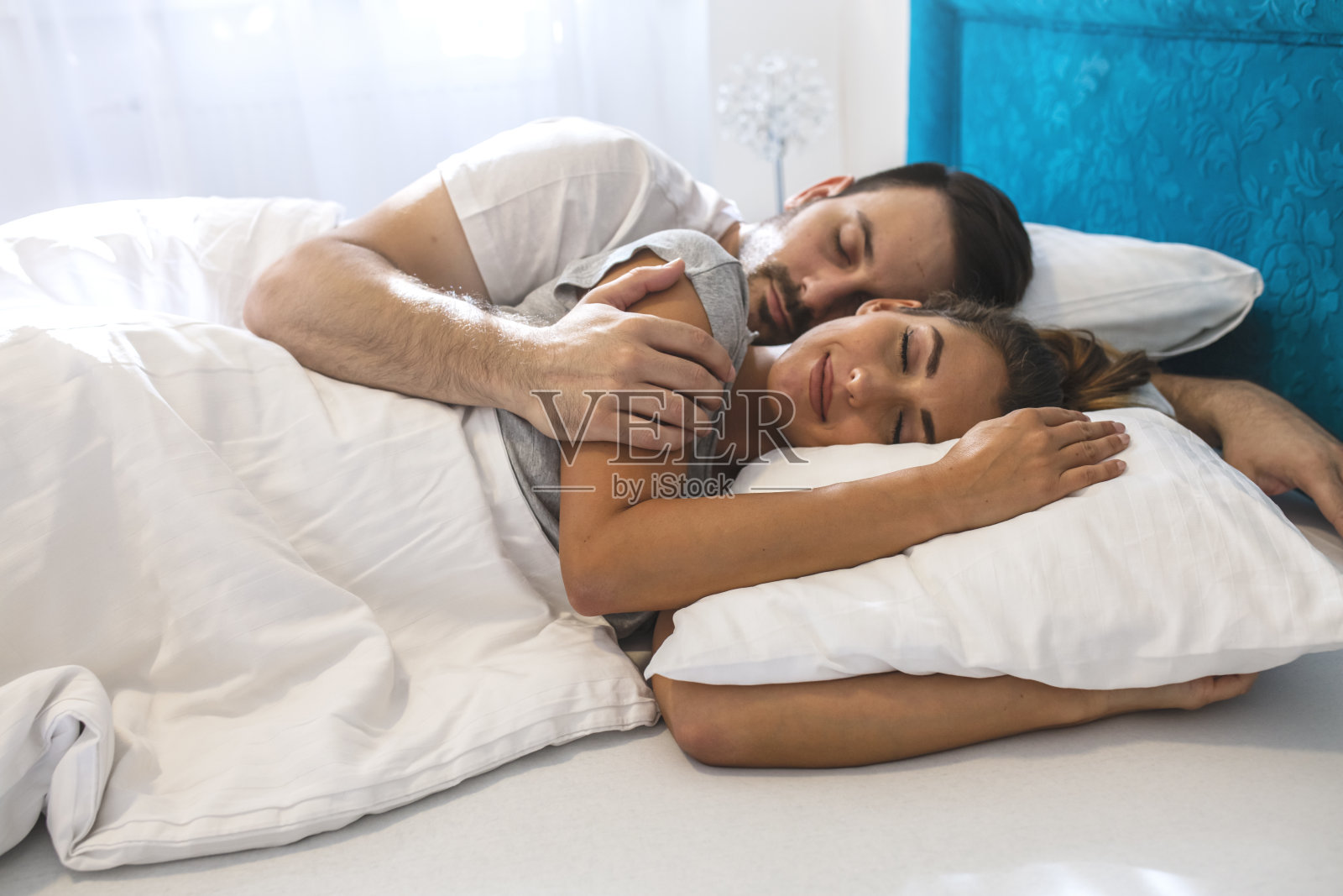 一对幸福的夫妇睡在家里舒适的床上照片摄影图片