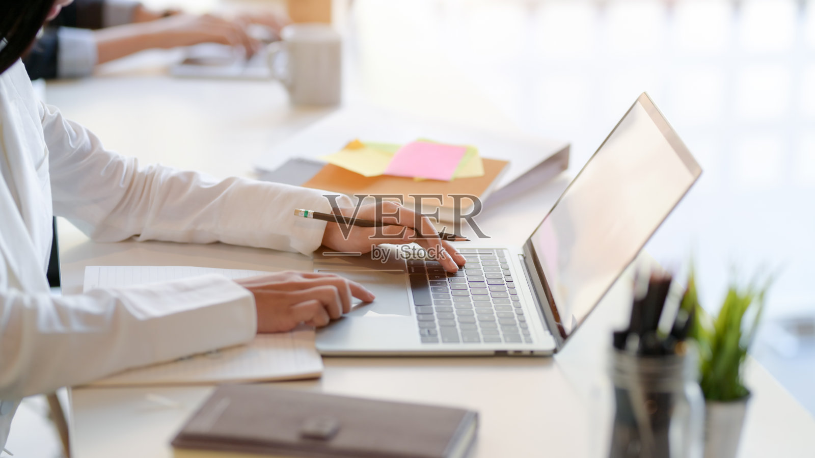 侧面的专业商人打字在空白屏幕笔记本电脑和办公用品照片摄影图片