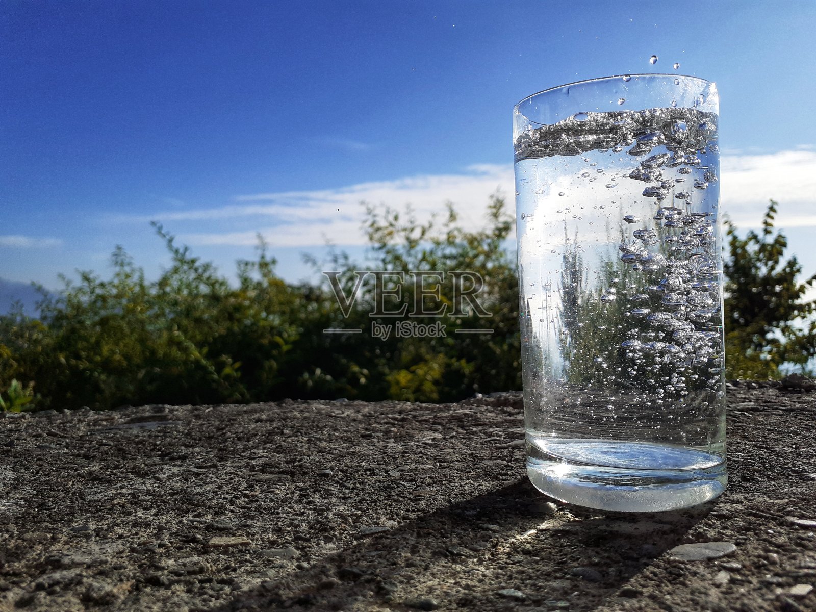 一杯满是冒泡泡的水。照片摄影图片