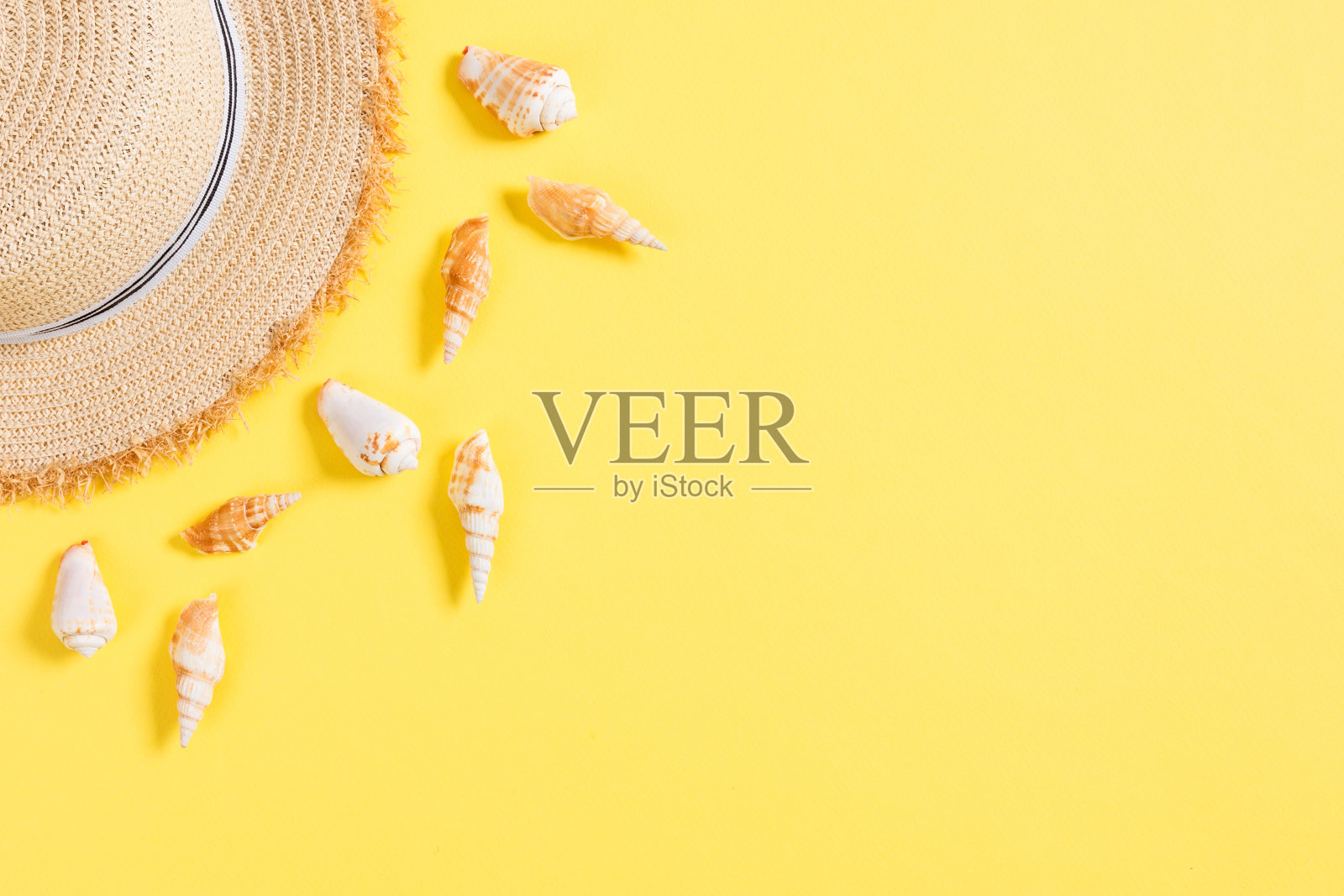 带贝壳的沙滩帽放在黄褐色的桌子上。夏季背景概念与拷贝空间俯视图照片摄影图片
