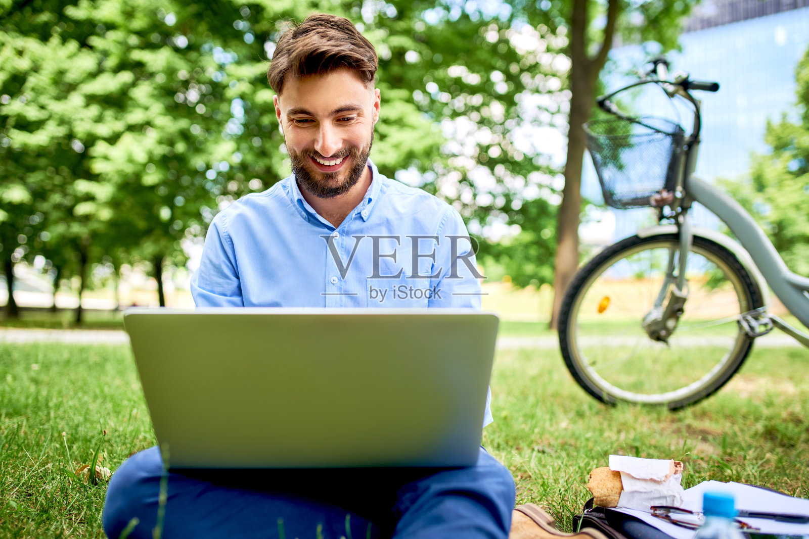 一幅欢快的年轻人用笔记本电脑在公园里吃午饭的照片照片摄影图片