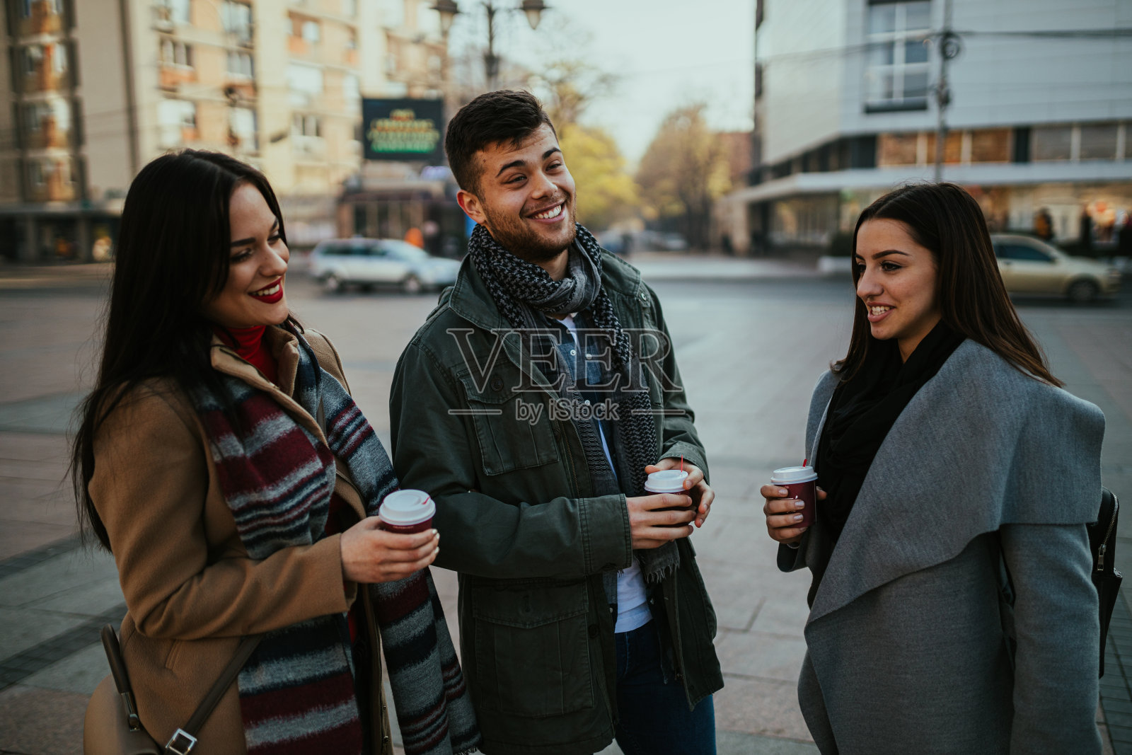 快乐的年轻人在城市的街道上喝咖啡照片摄影图片