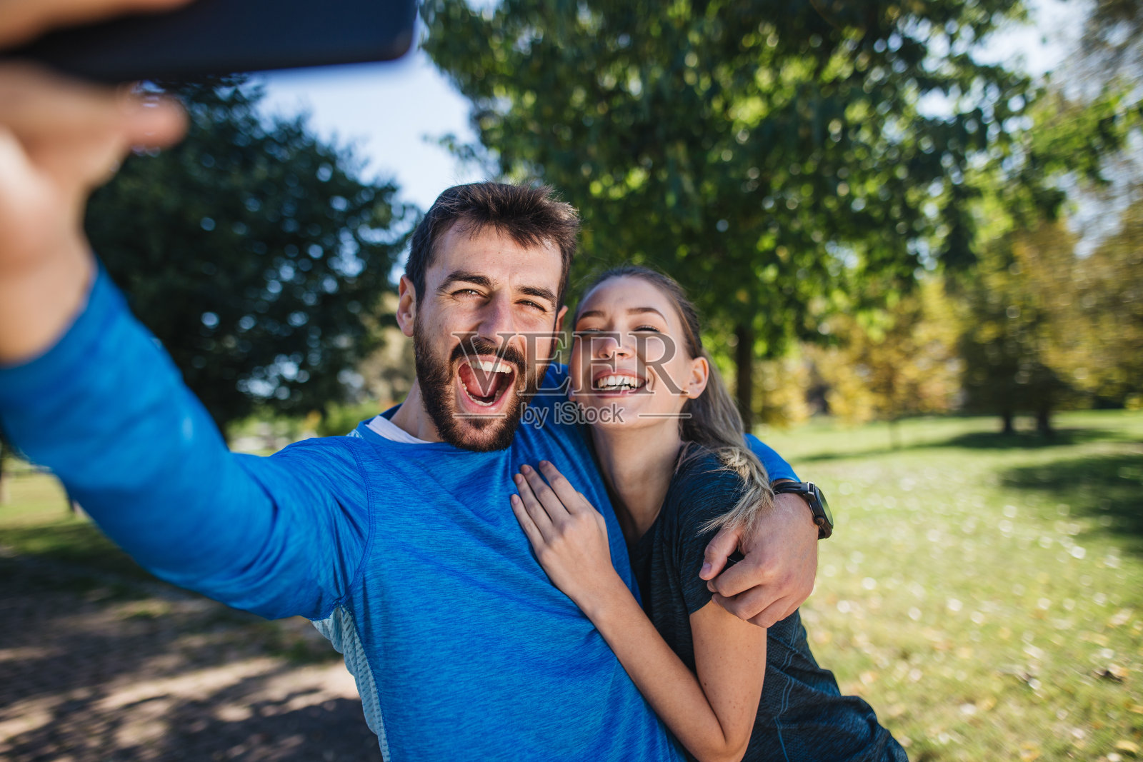 一对快乐的年轻夫妇在一起自拍时做鬼脸照片摄影图片