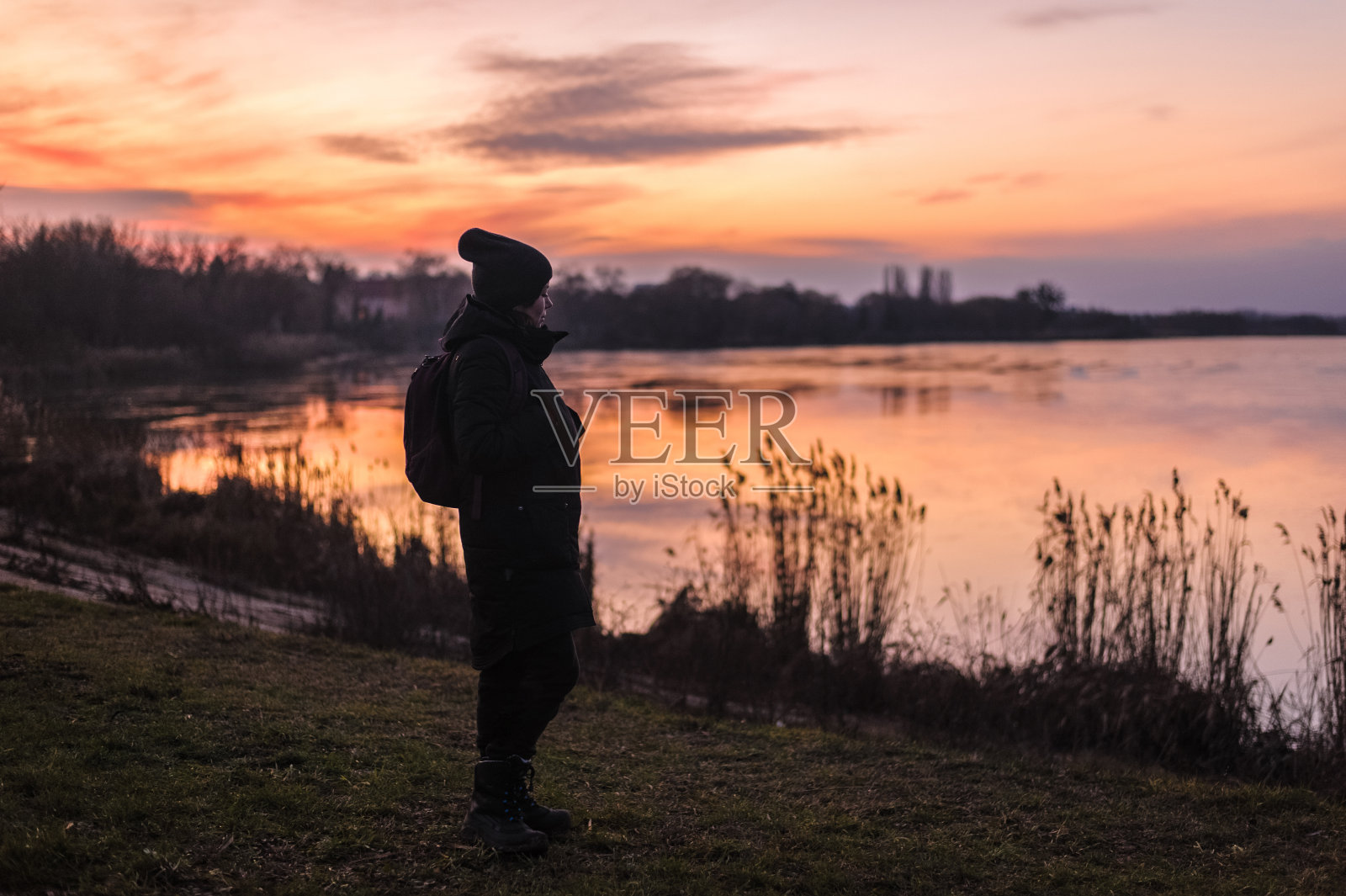 一个人的剪影在一个湖泊的背景在森林看美丽的日落照片摄影图片
