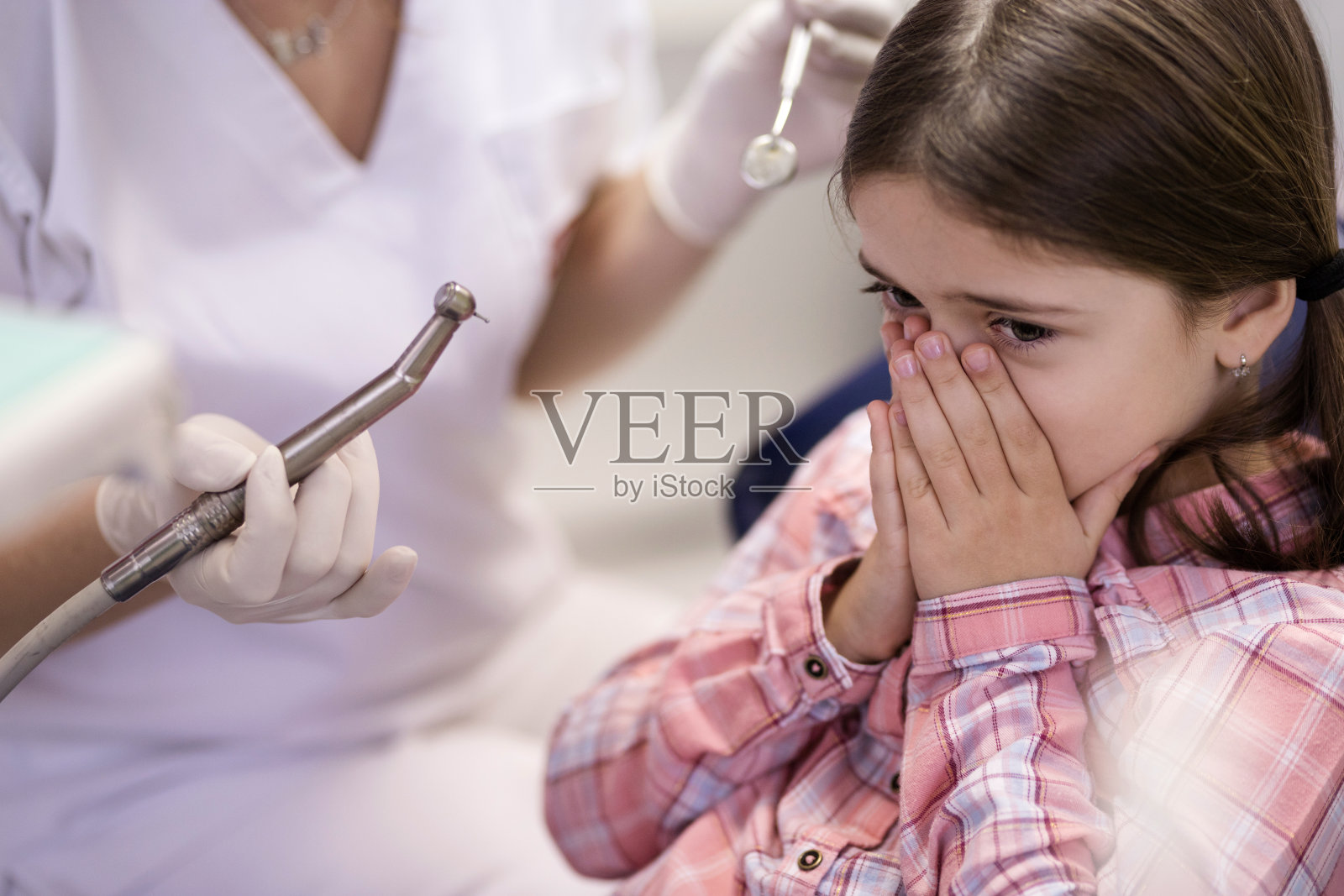 小女孩在看牙医的时候捂着嘴照片摄影图片