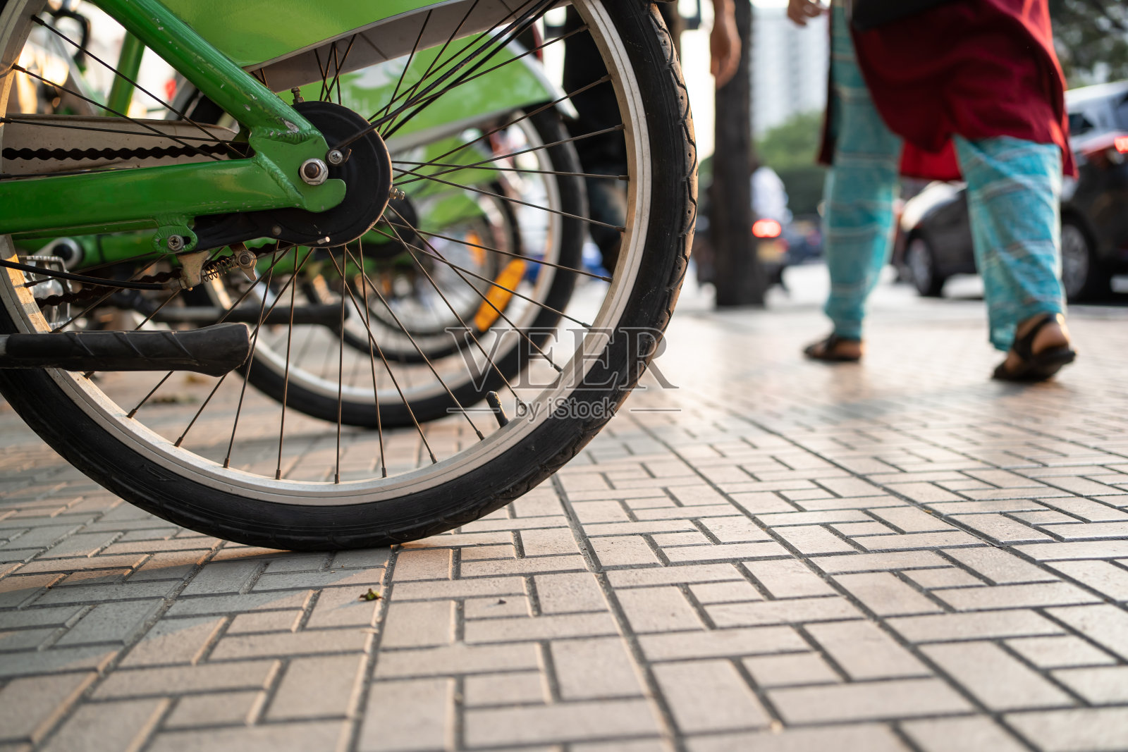 自行车轮子在人行道上与行人步行照片摄影图片
