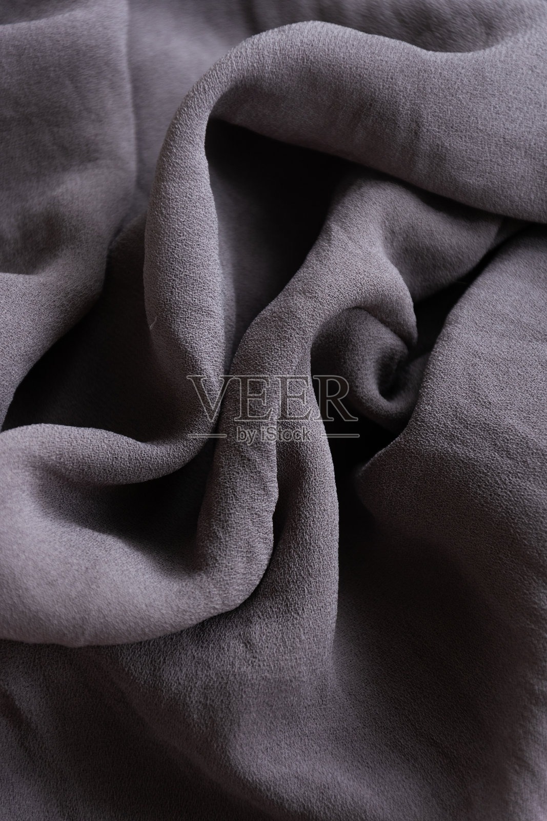 折叠丝绸深色调布。流行民族织物的作物观点照片摄影图片