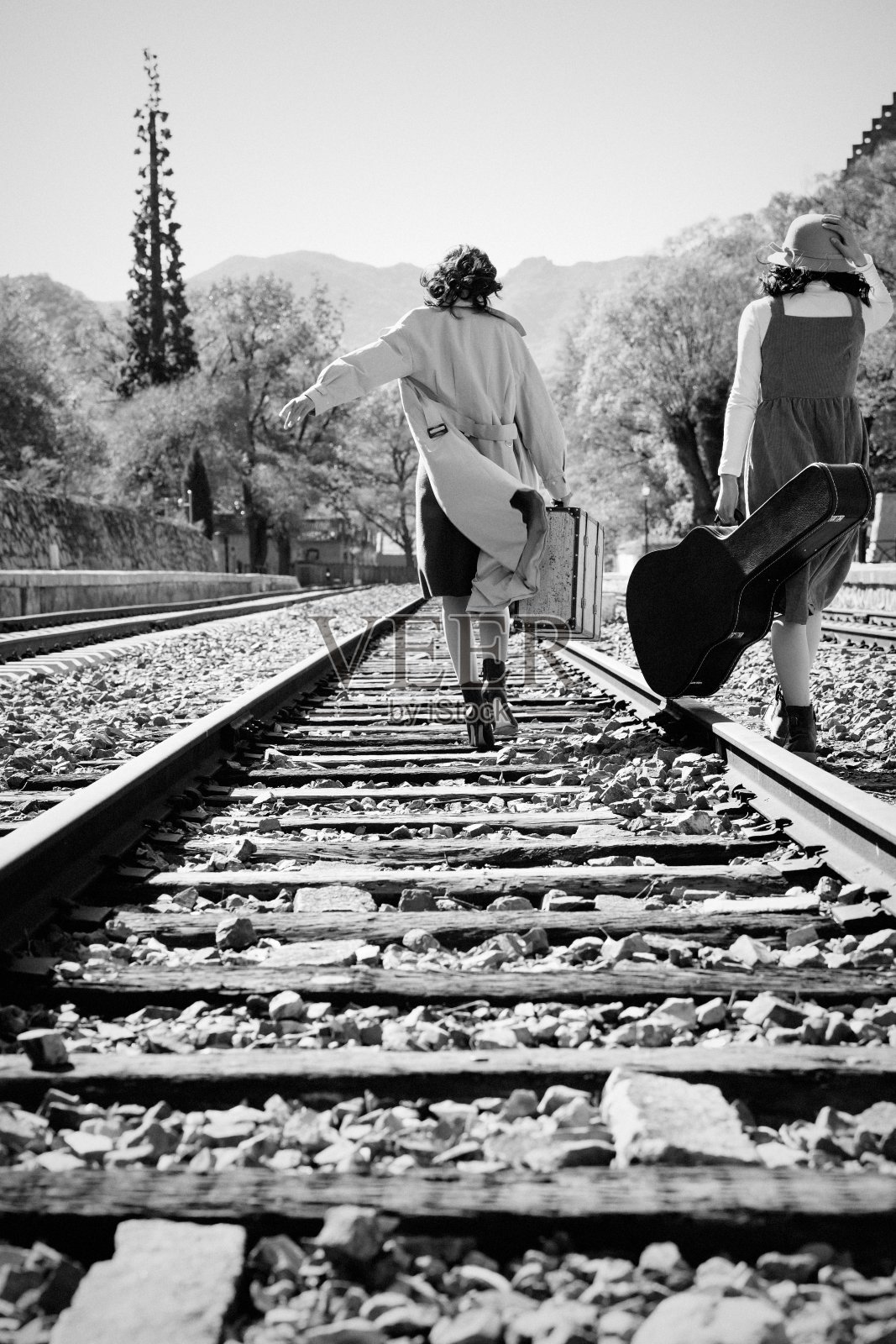 青年闺蜜走在铁轨上照片摄影图片