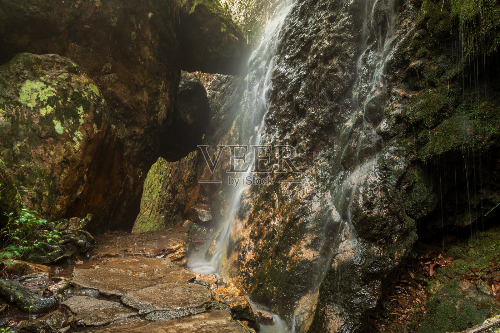瀑布倾泻在徒步旅行的小径上照片摄影图片