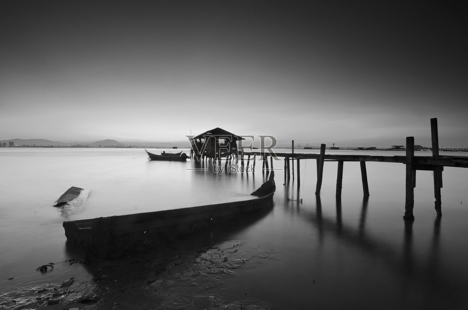 长曝光图像的老废弃渔民码头在黑白。照片摄影图片