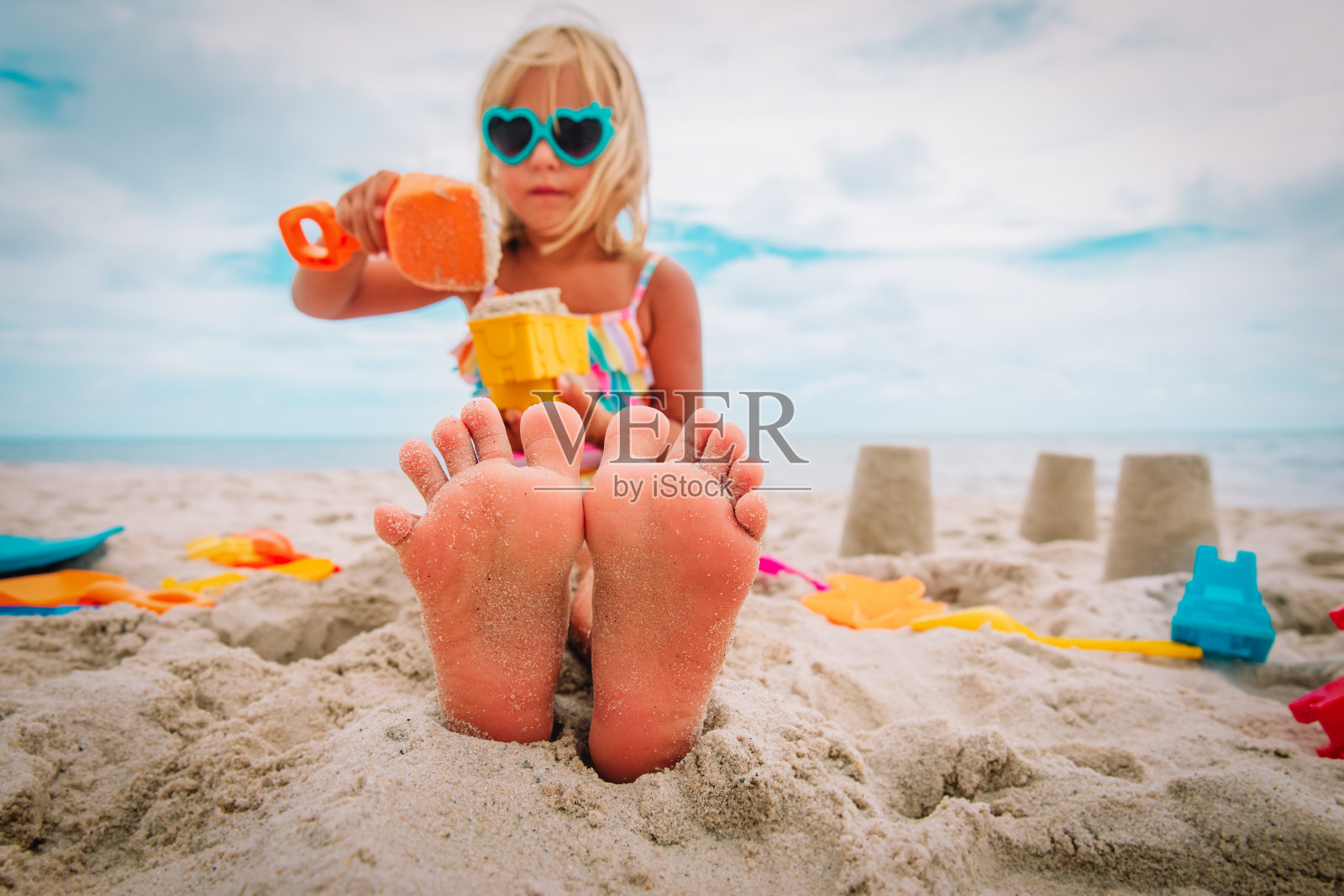 小女孩的脚在热带海滩上玩沙子照片摄影图片