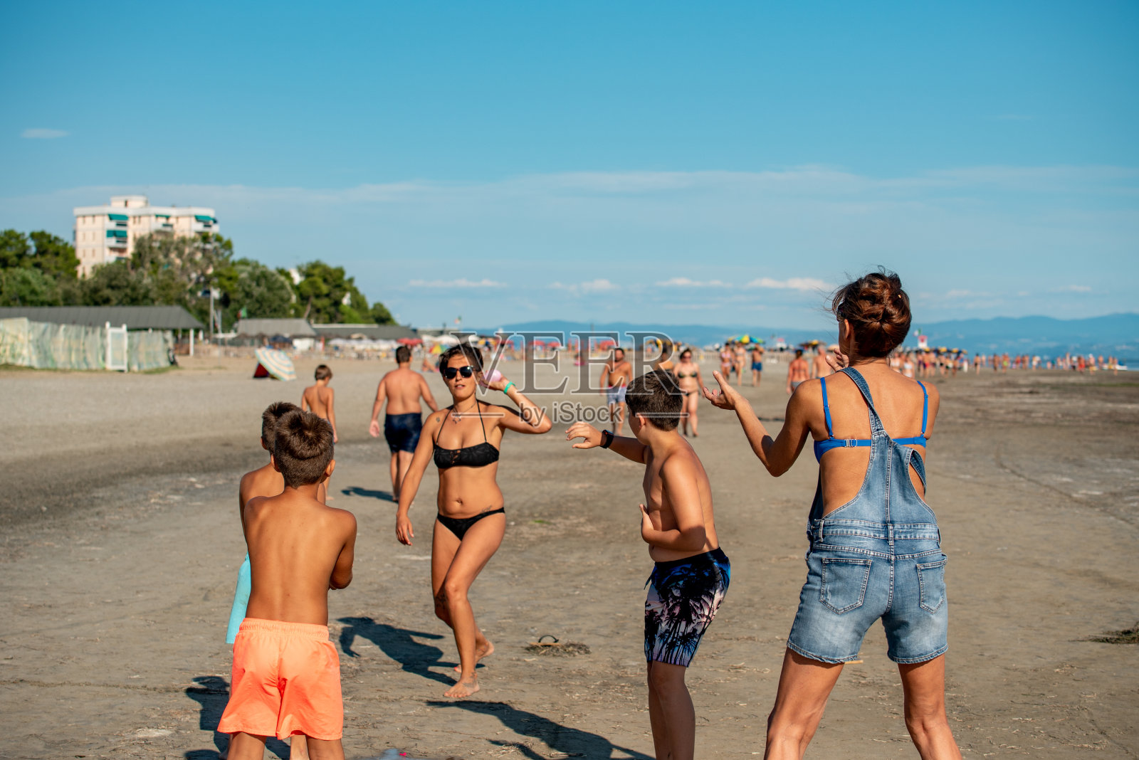 快乐的家庭扔水炸弹在夏天的沙滩上-库存照片照片摄影图片