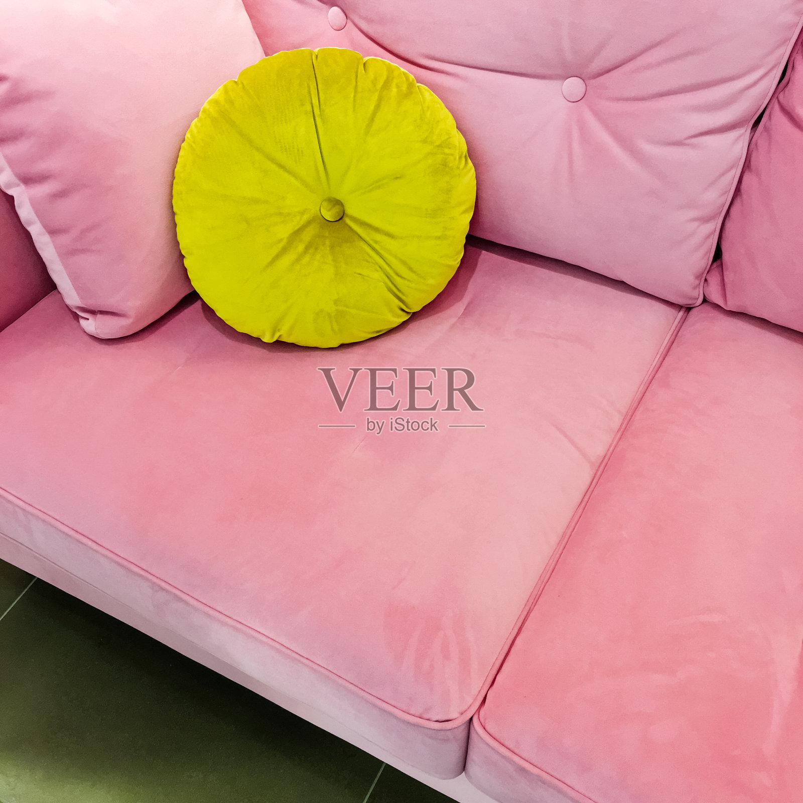 粉红色天鹅绒沙发，有别致的绿色靠垫照片摄影图片