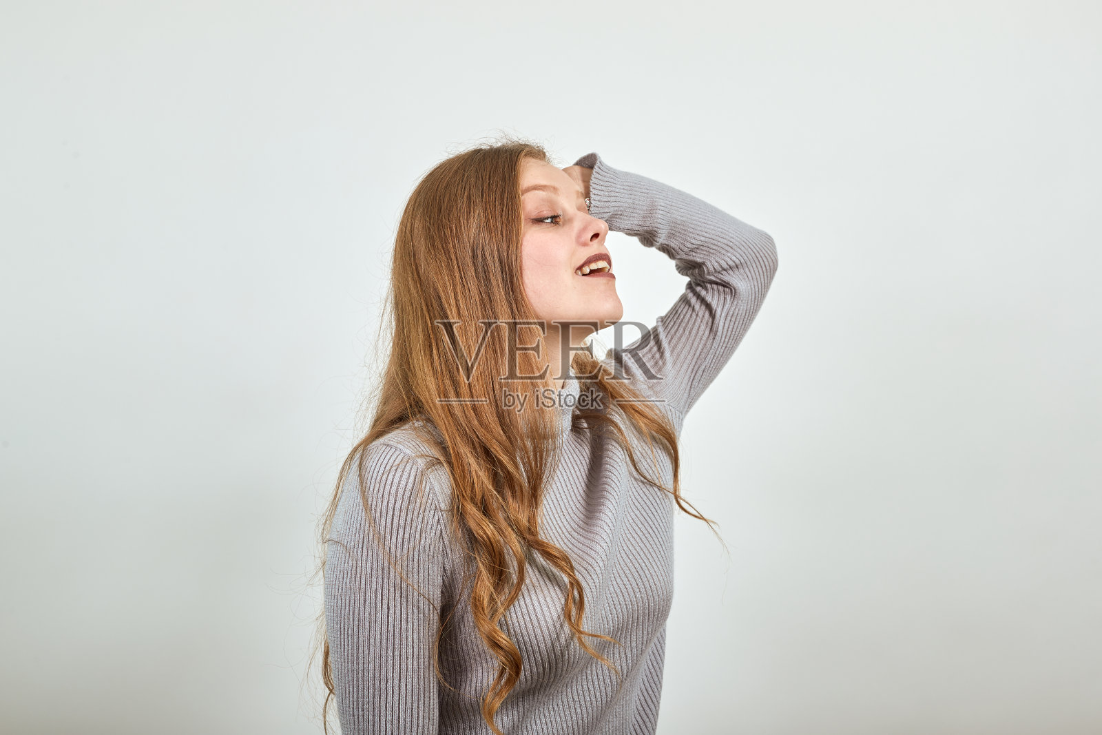 一个年轻漂亮的红头发女人在灰色毛衣的想法产生了新的想法照片摄影图片