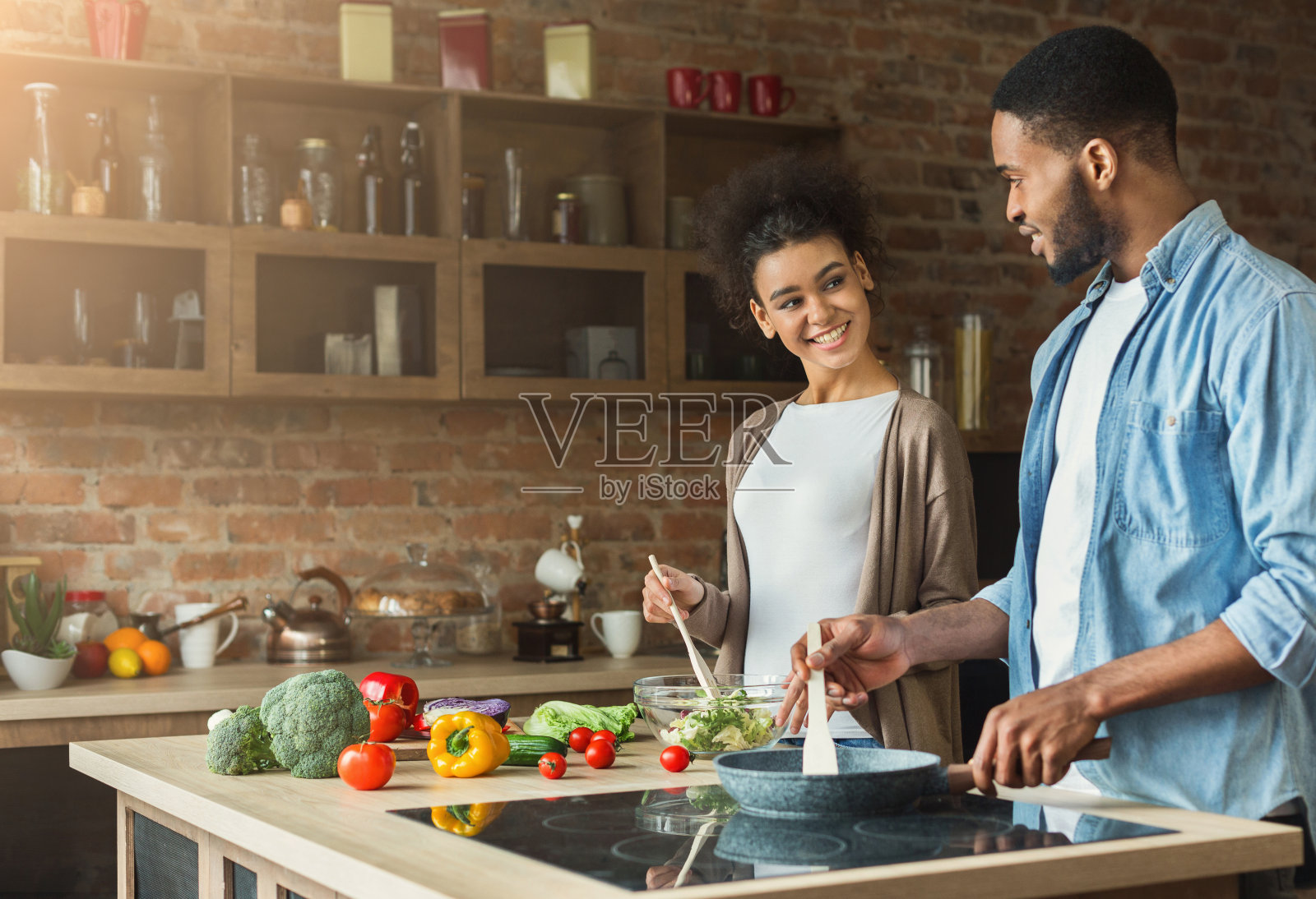 一对可爱的非洲裔美国夫妇正在阁楼厨房里准备晚餐照片摄影图片