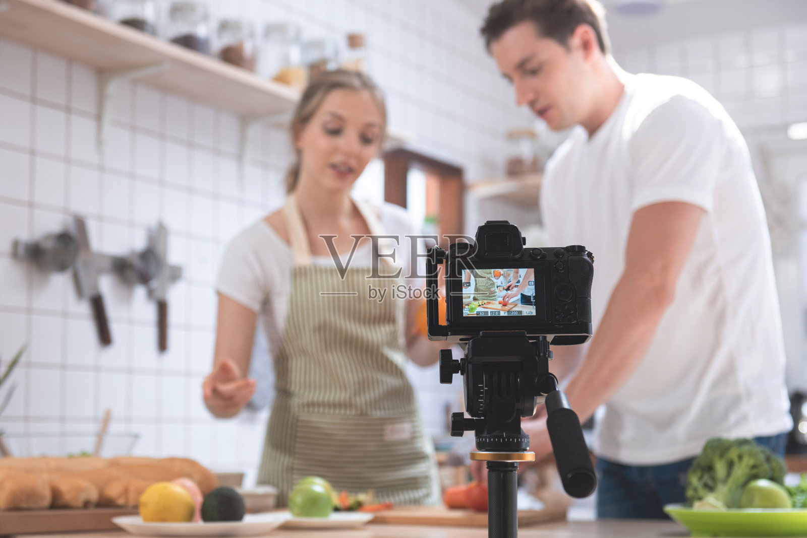 专业的数码无反光镜相机，记录幸福的白种夫妇在厨房做饭视频博客照片摄影图片