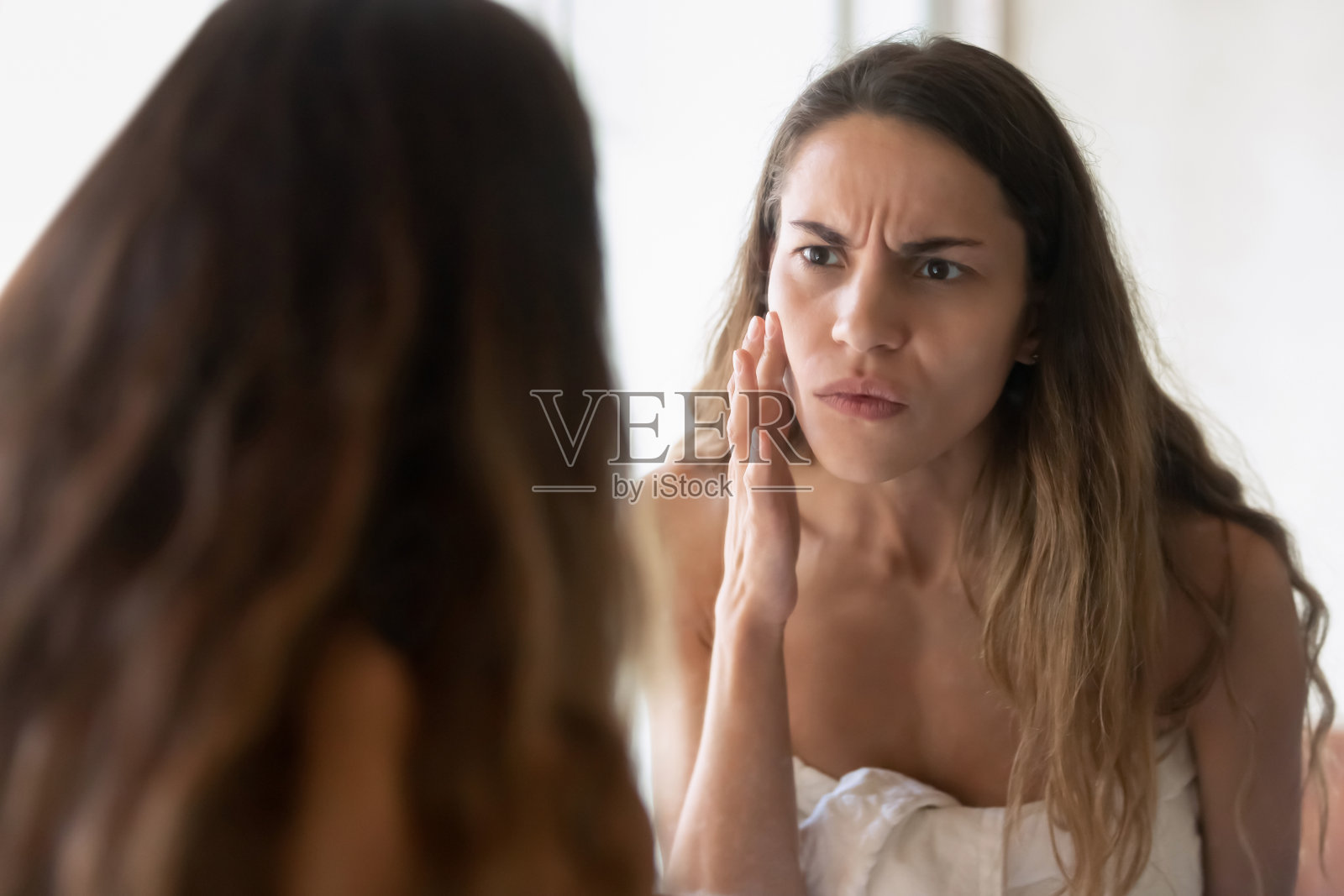 焦虑的年轻女子照镜子担心皮肤问题照片摄影图片