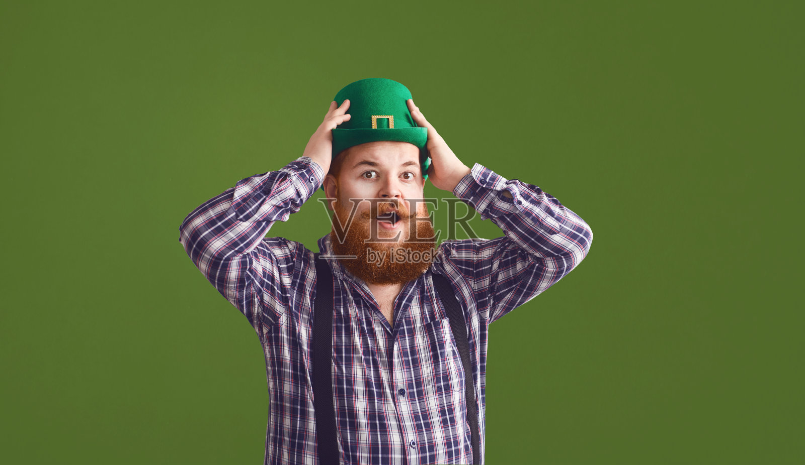 圣帕特里克节快乐。胖滑稽的人戴着绿色的帽子微笑在绿色的背景帕特里克日。照片摄影图片