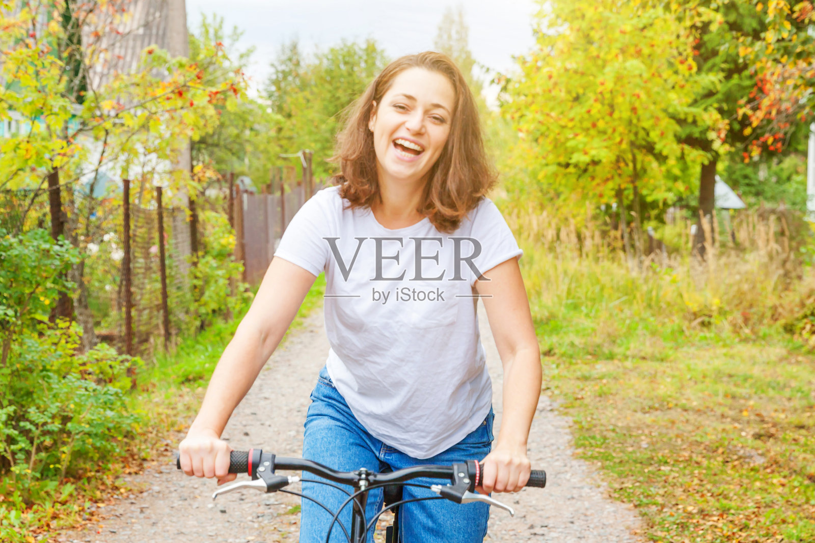 年轻女子骑自行车在夏季城市公园户外。活跃的人。嬉皮士女孩放松和骑自行车。在夏天骑自行车去上班。自行车和生态生活理念照片摄影图片