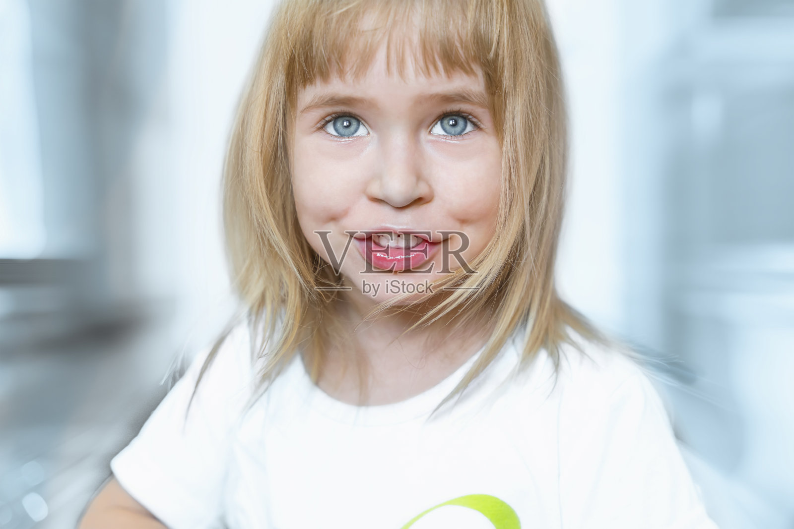 一个迷人的金发碧眼小女孩的肖像。可爱的孩子微笑着，快乐着。照片摄影图片
