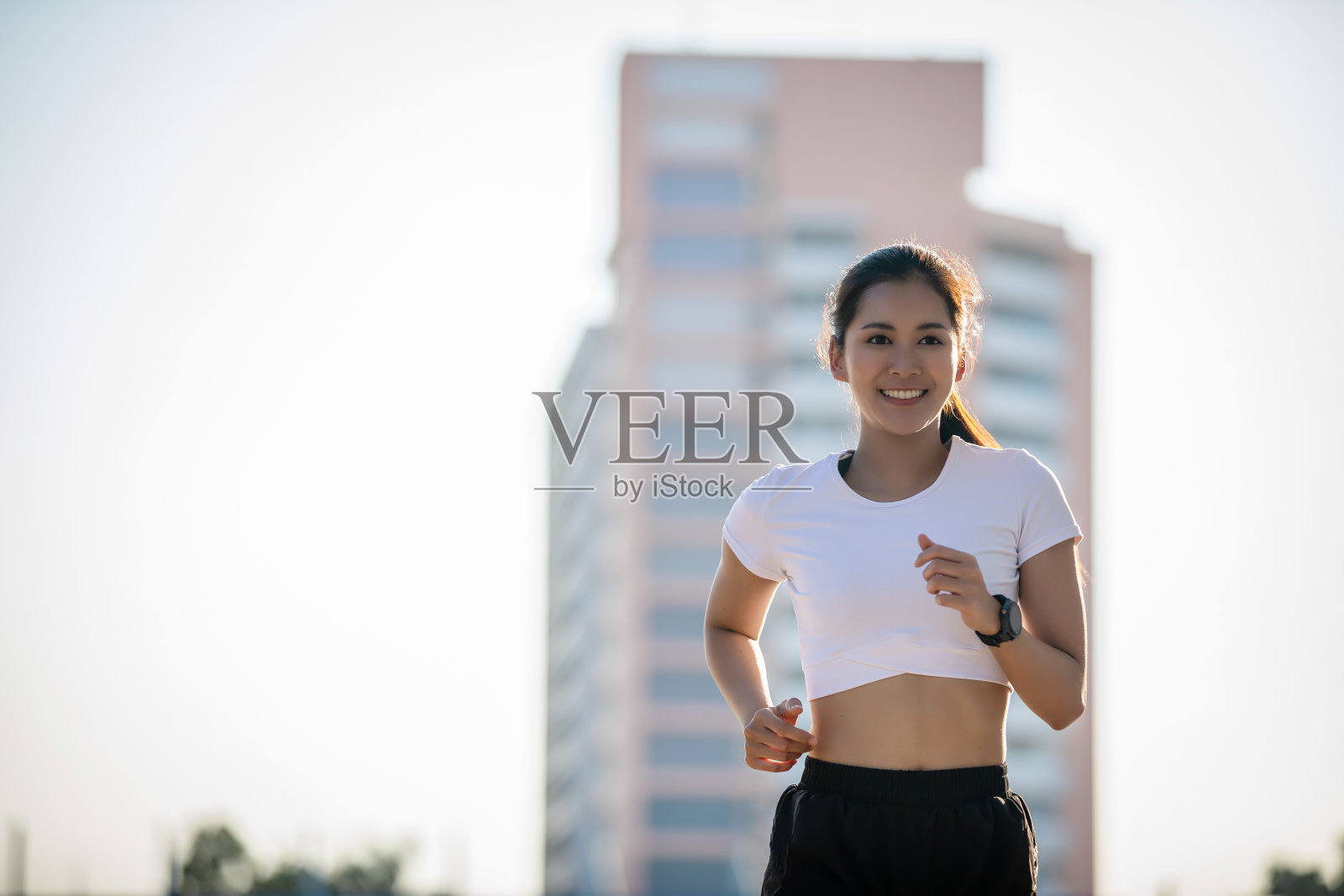亚洲年轻的健身运动女性在城市道路上跑步和微笑照片摄影图片